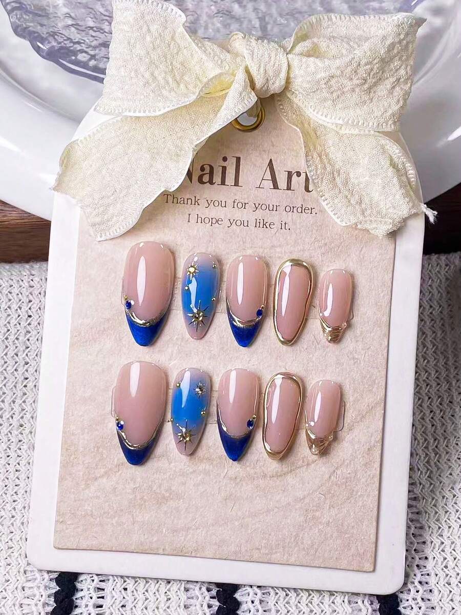Bộ 10 móng giả kiểu Pháp hình hạnh nhân màu xanh mắt mèo, được trang trí bằng các vòng tròn vàng và họa tiết ngôi sao tỏa sáng, với phần đầu móng được vẽ tay màu xanh mắt mèo, phần đầu móng màu vàng và các đường kẻ vàng bất đối xứng, cũng như kỹ thuật nhuộm tie-dye thủ công màu xanh lam, điểm nhấn là các hình dán ngôi sao tỏa sáng màu vàng và đá pha lê màu xanh lam. - Nhiều màu - Xem 1