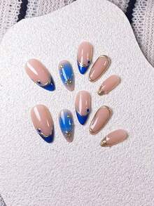 Bộ 10 móng giả kiểu Pháp hình hạnh nhân màu xanh mắt mèo, được trang trí bằng các vòng tròn vàng và họa tiết ngôi sao tỏa sáng, với phần đầu móng được vẽ tay màu xanh mắt mèo, phần đầu móng màu vàng và các đường kẻ vàng bất đối xứng, cũng như kỹ thuật nhuộm tie-dye thủ công màu xanh lam, điểm nhấn là các hình dán ngôi sao tỏa sáng màu vàng và đá pha lê màu xanh lam. - Nhiều màu - Xem 4