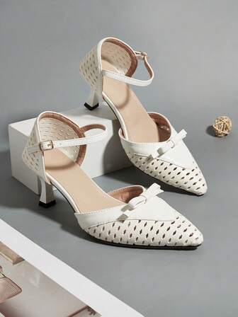白色PU皮革镂空雕花蝴蝶结装饰细高跟鞋，适合日常穿着、宴会、派对等场合，时尚百搭。镂空雕花图案和蝴蝶结方向随机。