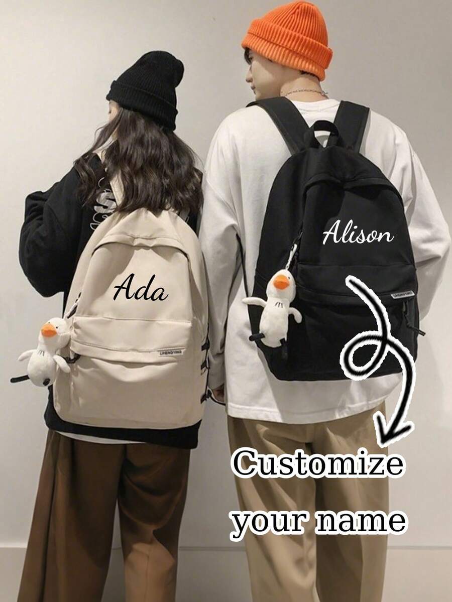Ba lô đôi cá nhân hóa với mặt dây chuyền hình ngỗng trắng nhỏ trên dây đeo vai, có thể tùy chỉnh tên. Thiết kế dung tích lớn, lý tưởng cho du lịch, dã ngoại, leo núi và cắm trại.