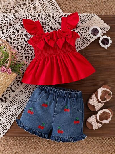 2pcs Baby Girl Sweet & Spicy Style Backless Bow Tie Sleeveless Ruffle Strap Camisole Top And Cherry Embroidery Ruffle Hem Denim Shorts Set