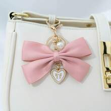 1个布艺蝴蝶结和仿珍珠心形钥匙扣，适合作为生日礼物、情人节礼物、汽车装饰、包包挂饰或情侣或女友的学习用品。 - 兔耳蝴蝶結 - 查看 5