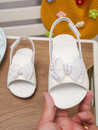 1 par flickors vår- och sommarsandaler med rosett och strass, mjuk sula, öppen tå, platta prinsessandaler, mångsidiga halkfria romerska skor, lämpliga för resor, semester och skolkläder