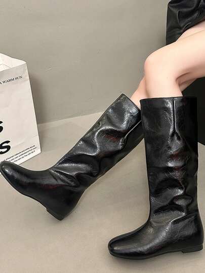 黑色中筒套脚靴，平底方头，舒适百搭，优雅时尚，四季皆宜，简约欧式风格，适合办公、通勤、日常穿着和度假。