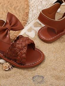 1双儿童棕色蝴蝶结装饰PU材质防滑耐用软底鱼头圆头一脚蹬设计沙滩风儿童平底凉鞋，适合3-15岁男孩女孩日常穿着、上学、散步、生日派对、玩耍等场合，2026春夏新款凉鞋