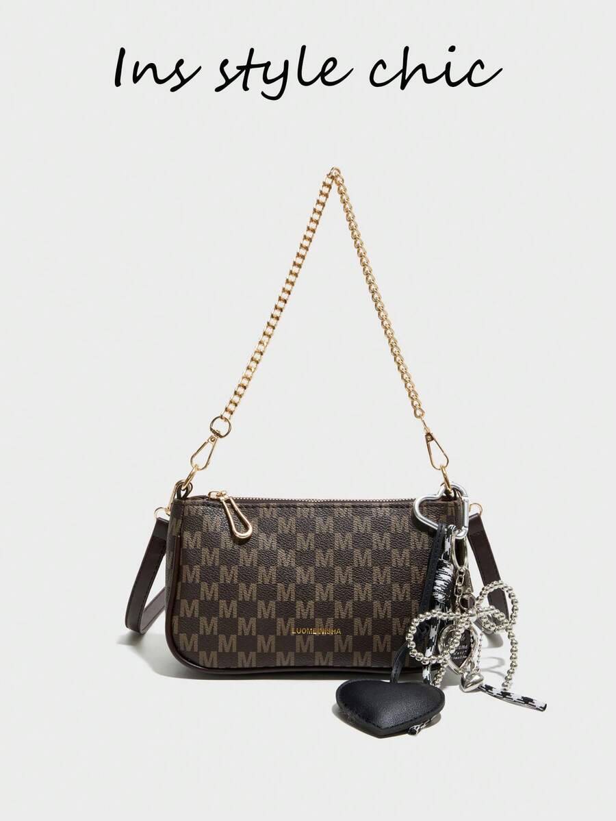 这款肩背包采用纯咖啡色设计，面包形包身饰以字母图案印花，并点缀着黑色心形吊坠。包口配有金属链条，搭配可调节长肩带，可单肩背、斜挎或手提。顺滑的拉链设计，内部空间充足，可收纳口红等日常必需品。