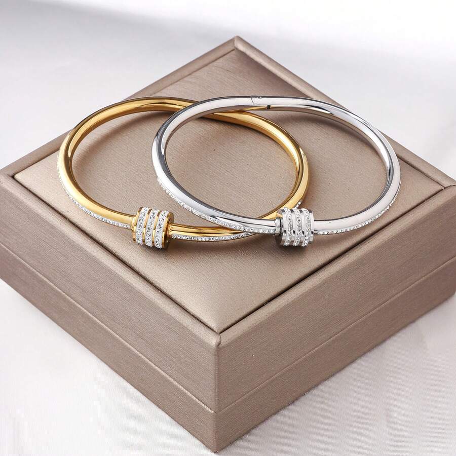 Một chiếc vòng tay bằng thép không gỉ thời trang với hình dáng cột thanh lịch, được trang trí bằng ba hàng đá lấp lánh. Nó có khả năng chống nước và không phai màu, là món quà hoàn hảo cho những người yêu thích trang sức thời trang. - vòng đeo tay - Xem 1