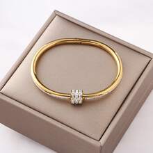 Một chiếc vòng tay bằng thép không gỉ thời trang với hình dáng cột thanh lịch, được trang trí bằng ba hàng đá lấp lánh. Nó có khả năng chống nước và không phai màu, là món quà hoàn hảo cho những người yêu thích trang sức thời trang. - vòng đeo tay - Xem 6