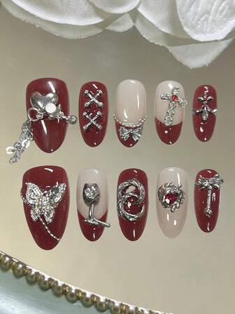 Este juego de arte de uñas incluye 10 uñas largas con forma de almendra hechas a mano con estilo francés. Presumiendo de un estilo dulce y fresco con elementos como gemas de mariposa, gemas de flores, cadenas, lazos, rhinestones y remaches metálicos, también incorpora un toque gótico. Estas uñas tienen un brillo brillante y son productos de uñas postizas que se pueden despegar fácilmente.