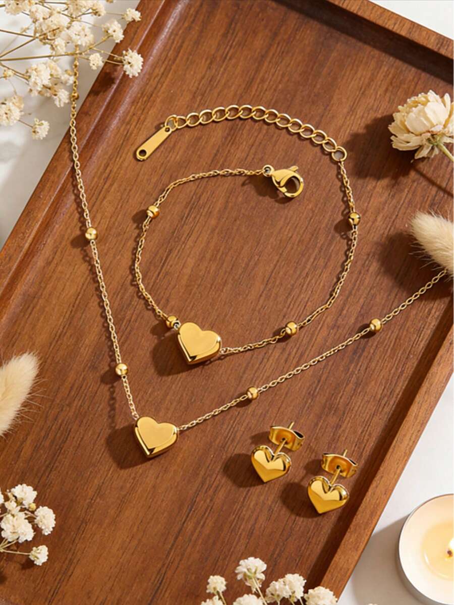 Bộ trang sức thép không gỉ lãng mạn gồm dây chuyền hạt thép bất đối xứng và mặt dây chuyền hình trái tim, kèm vòng tay và bông tai cùng kiểu, thích hợp cho phụ nữ đeo khi hẹn hò, đi mua sắm hoặc làm quà tặng Ngày Valentine cho người yêu. - Vàng - Xem 1