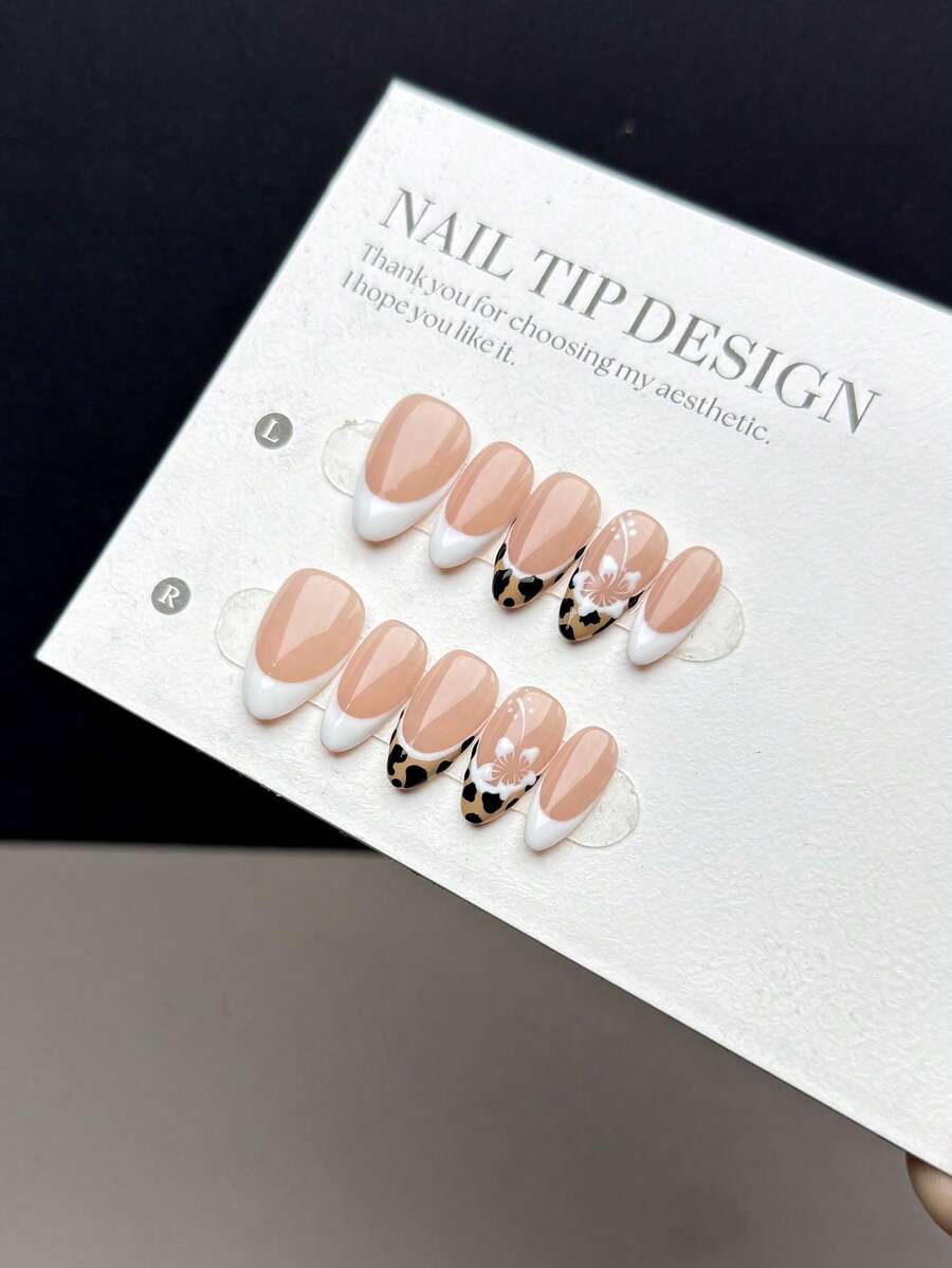 10片纯手工制作的可佩戴人造指甲片，短款杏仁形，按压式设计，时尚简约。指甲片上饰有纯手工绘制的白色和豹纹法式美甲图案，并点缀着精美的手绘白色雪花图案。这是一款高端美甲贴片，适合女性和女孩日常佩戴，套装包含10片指甲片。美甲用品 手工按压式指甲片 - 彩色 - 查看 1