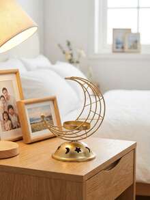 一套多层新月星空心金属烛台。这款烛台采用金属丝和金属底座制成，设计简约现代。其造型由交织的新月形框架和带有星月镂空图案的圆顶底座组成，并配有一个小巧的蜡烛托盘。 - 彩色 - 查看 10