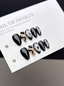 10片纯手工制作的按压式美甲贴片，短杏仁形甲型，风格深沉神秘。贴片上绘有手工绘制的黑色恶魔之眼，以及纯手工绘制的立体黑色盘绕蛇纹，并饰以蛇形图案和不对称线条设计。 - 彩色 - 查看 2