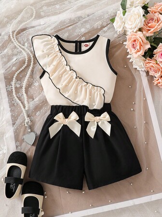 Moderiktigt och avslappnat set för unga flickor: Plisserad ärmlös topp med pärlor + plisserade byxor med rosett