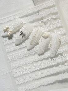 一款复古精致的美甲贴纸，采用浮雕纹理，主要由白色蕾丝制成，包括波浪边缘、花卉图案、镂空图案和其他蕾丝款式，适合个人DIY和打造法式新娘美甲风格。