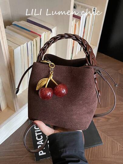 Denna snygga och klassiska handväska har en enfärgad design med ett topphandtag och en körsbärsberlock, vilket gör den perfekt för vardagsbruk och resor. Oavsett om det är för jobbet, shopping eller en dejt, är det det perfekta valet för dina dagliga utflykter.