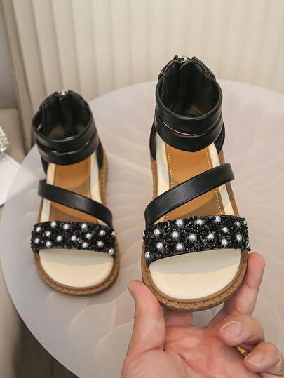 Giày sandal đính ngọc trai sequin mới cho bé gái mùa Xuân/Hè 2026, sandal đế bằng kiểu La Mã với hai quai ngang mắt cá chân, đa năng cho tiệc tùng và kỳ nghỉ.