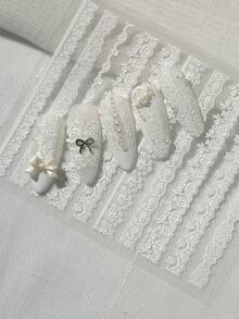 一款复古精致的美甲贴纸，采用浮雕纹理，主要由白色蕾丝制成，包括波浪边缘、花卉图案、镂空图案和其他蕾丝款式，适合个人DIY和打造法式新娘美甲风格。