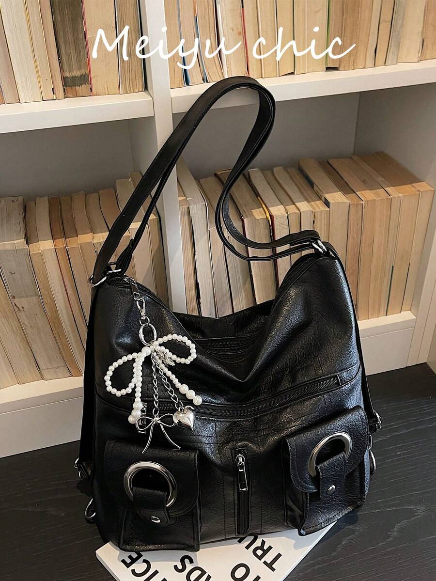 这款时尚简约的大容量女士通勤单肩包采用PU材质，饰有珍珠心形吊坠，搭配镂空铆钉拉链，并配有肩带和手提带。它适合旅行、通勤和学生使用，既可作为旅行背包，也可作为休闲背包。