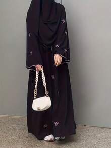 这款女士优雅长裙适合当季穿着，饰有蝴蝶结印花和荷叶边袖口，适合节日、婚礼、度假和日常穿着。简约的伊斯兰长袍，点缀粉色蝴蝶结——A字型黑色女士长裙（无弹力面料，圆领款式）春季款 - 黑色 - 查看 4