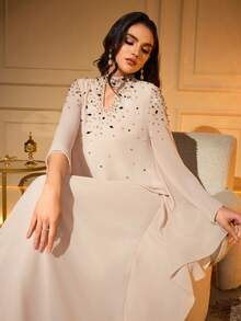 Đầm Abaya tay dài dáng cánh dơi thanh lịch, trang trí bằng hạt cườm và đá pha lê ở cổ áo khoét hình giọt nước, được làm từ vải dệt không co giãn, hoàn hảo cho những dịp đặc biệt mùa xuân. - Màu be - Xem 7