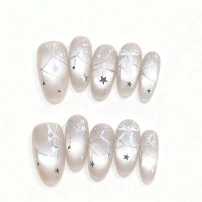 10片装“日光流星”美甲贴片——以柔和的香槟色为底色，融合了银色闪粉、精致的星形图案和3D白色蝴蝶结。微妙的闪光模仿了日光下流星的微弱光芒，在空灵魅力与低调优雅之间取得了完美的平衡。它是为任何造型增添柔和光泽的理想之选。美甲用品 手工按压式美甲贴片