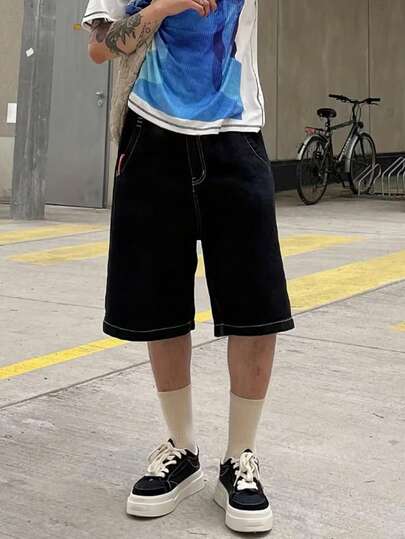 青少年/青年男童黑色牛仔短裤，饰有白色涂鸦细节，宽松街头风