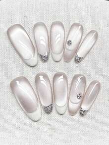 10片纯手工制作的长款椭圆形美甲贴片，底色为裸色猫眼，搭配白色法式和银色闪光法式，并饰以白色曲线和小水钻。元素简约精致，优雅而富有层次感。温柔优雅可爱的美甲，适合女士和女孩在春夏秋冬的各种节日派对和日常生活中使用。 - 白色 - 查看 2