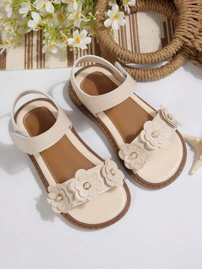 1 đôi sandal công chúa hở mũi cho bé gái, trang trí bằng ngọc trai và hoa, làm từ chất liệu PU, thiết kế mềm mại và thoải mái. Kiểu đế thấp, có quai dán, gót bằng, những chi tiết ngọt ngào mộng mơ phù hợp cho cả mặc hàng ngày và các dịp lễ hội.