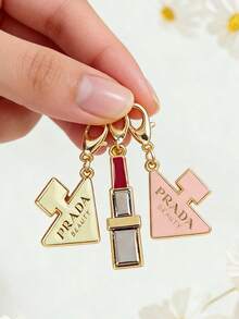 Prada 这款钥匙扣采用不锈钢材质，造型为香水和口红。它可以作为装饰吊坠、包包配饰或挂饰，适合装饰背包、挂在钥匙链上，是生日、节日、圣诞节或新年送给家人和朋友的理想礼物。 - 粉紅白色 - 查看 7