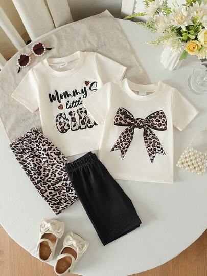 新款女婴短袖圆领简约可爱蝴蝶结字母印花上衣，搭配豹纹和纯色短裤两件套，适合外出、日常休闲和旅行。