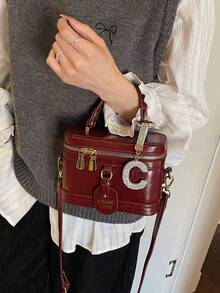 这款女士纯色PU皮手提包，酒红色调，设计时尚百搭，外部饰有水钻C形吊坠。包身呈方形，配有字母标签、顶部光滑的金属拉链和单提手。可调节长肩带方便肩背。 - 酒紅色 - 查看 7