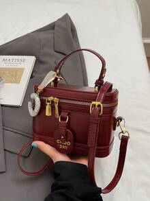 这款女士纯色PU皮手提包，酒红色调，设计时尚百搭，外部饰有水钻C形吊坠。包身呈方形，配有字母标签、顶部光滑的金属拉链和单提手。可调节长肩带方便肩背。 - 酒紅色 - 查看 4