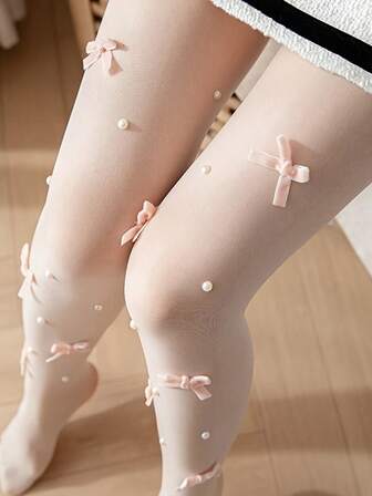 一双女士透明连裤袜，饰有迷人的蝴蝶结和珍珠点缀，非常适合夏季日常穿着。