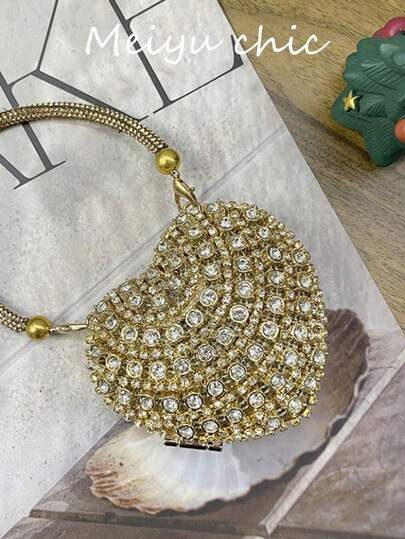 这款奢华迷你镶钻心形水晶手拿包饰有闪亮水钻，是晚宴、婚礼及其他场合的完美之选。它配有手柄，可用作单肩包或手提包。