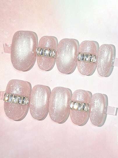 10片纯手工制作的中号椭圆形美甲贴片，浅粉色猫眼底色搭配银色钻石链装饰。简洁的线条营造出优雅的气质，提升精致感而不失柔美，适合女士和女孩在春夏秋冬的各种场合，如节日、派对和日常生活中使用。