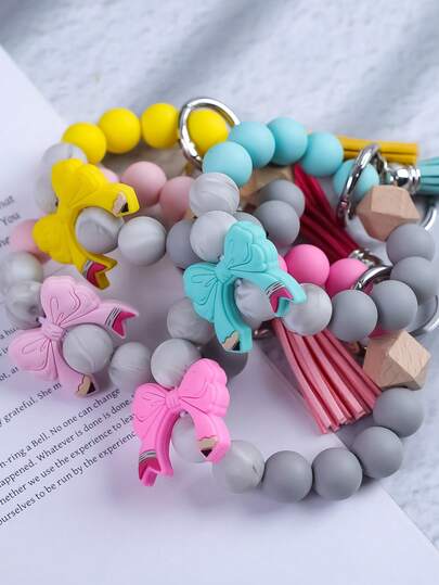 1个双色蝴蝶结流苏钥匙扣，哑光硅胶珠吊坠配饰，适合日常穿搭