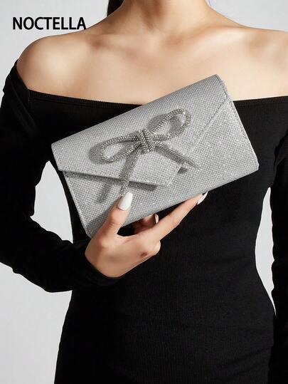 Noctella 这款闪亮的银色信封手拿包饰有水钻蝴蝶结，是一款魅力四射的晚宴配饰。它拥有闪亮的质感和优雅的蝴蝶结装饰，是派对、晚宴和各种活动的完美之选，能够提升整体造型的吸睛度，是送给女性的最佳礼物。