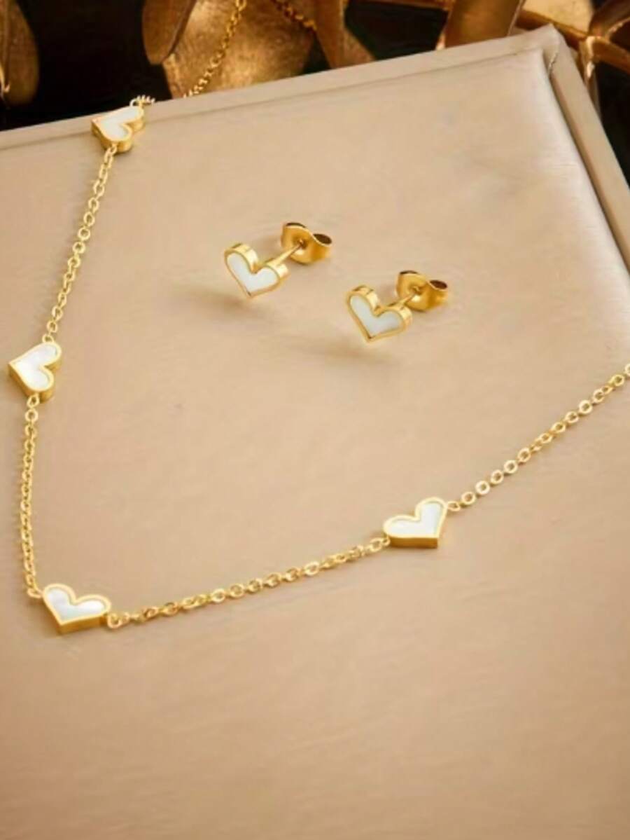 一套女士首饰套装，包括不锈钢耳环和心形吊坠项链，简约风格，是完美的节日礼物之选。