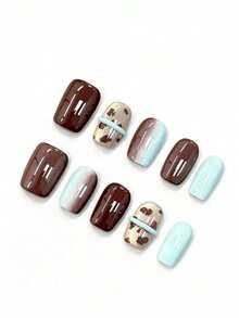 10片装，名为“巧克力牛奶云”。这款美甲以亮泽的深棕色搭配柔和的薄荷蓝底色，饰以渐变云朵图案、可爱的奶牛纹点缀和浅蓝色圆环装饰。浓郁的暖色调与清新的粉彩色调交织，营造出一种俏皮活泼的氛围，完美契合那些喜爱甜美又不失个性的美甲艺术，追求独特混搭风格魅力的人士。美甲用品 手工按压式美甲 - 彩色 - 查看 2