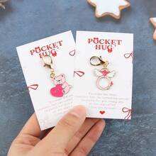 情人节礼盒套装，10件套，包含口袋拥抱卡片，是送给她/他的完美小礼物，也适合婚礼和派对。口袋拥抱卡片传递真挚的祝福。迷你可爱钥匙扣套装，包含心形、泰迪熊、蝴蝶结、酒杯、花束等多种图案，英文版。