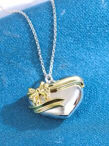 1件S925纯银心形丝带蝴蝶结吊坠项链，银色心形主体搭配镀金丝带和蝴蝶结装饰，浪漫优雅的设计，适合日常佩戴、约会或周年纪念日，也是一份很棒的情人节礼物。 - 銀色 - 查看 2