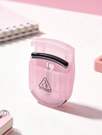 3CE Pink Portable Eyelash Curler. Long-Lasting Curling Makeup Tool. Comes With Replacement Pads. Recommended For Beginners To Create Natural Curled Lashes.