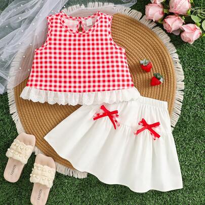 小女孩格子两件套，红色格子无袖上衣搭配白色荷叶边裙摆和蝴蝶结，甜美夏日儿童服装，适合海滩度假和日常穿着。