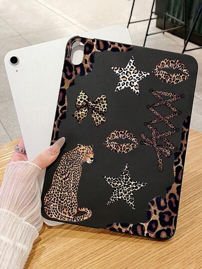Capa protetora para iPad com estampa de leopardo e patchwork, em preto fosco, com detalhes em estampa de leopardo, estrelas, laço, lábios e alças cruzadas. Compatível com iPad.