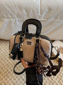 这款女士手提包采用撞色设计，饰有字母图案和小猫饼干吊坠。侧面采用菱形网格设计，并配有顺滑的金属拉链。包身设有双提手和可调节长肩带，方便您手提、肩背或斜挎。 - 黑色 - 查看 7