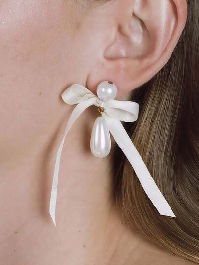 1对珍珠蝴蝶结耳钉，适合日常佩戴和节日场合。