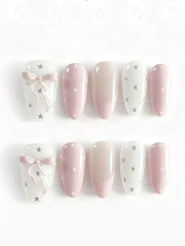10片装，名为“粉红星辰梦幻面纱”。这款美甲融合了柔和的腮红粉、轻盈的米白色和透明裸色底色，并点缀以精致的3D粉色蝴蝶结、闪亮的银色星星和低调的波点。柔和的粉彩色调和浪漫的细节营造出梦幻空灵的氛围，完美契合喜爱精致童话风格美甲，并追求柔美梦幻魅力的人士。