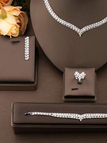一套奢华优雅的镶嵌立方氧化锆流线型首饰套装，适合女士婚礼和宴会佩戴，包含1对耳环、1条项链、1条手链、1枚戒指，不含礼盒。