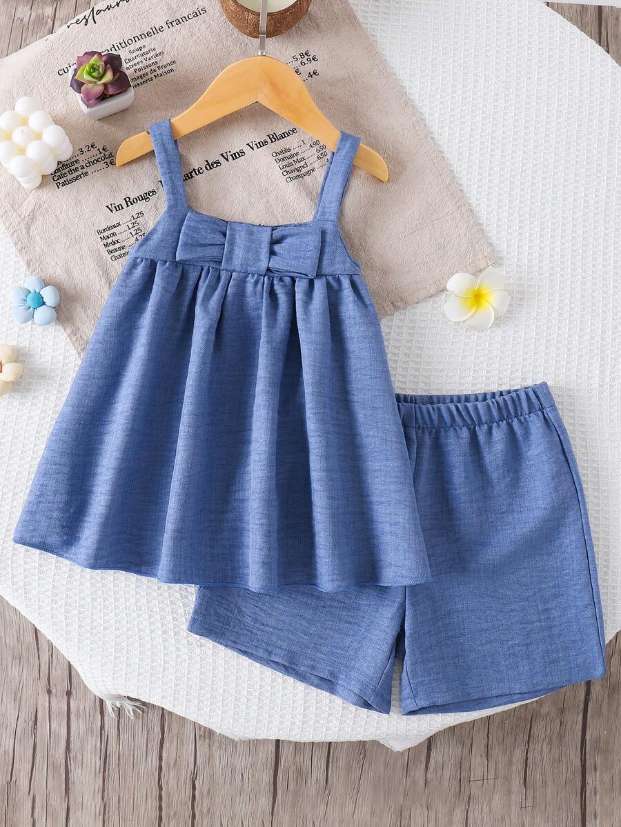 Bộ đồ thời trang trẻ em gái kiểu dáng giản dị, thanh lịch, ngọt ngào, chất liệu denim, cổ nơ, áo hai dây và quần short, thích hợp cho mùa hè.